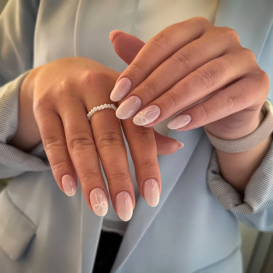 Nude ombré almond nails with white bow nail art and pearls